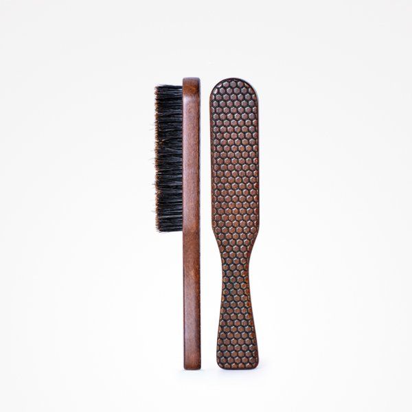 Un cepillo con mango de madera y cerdas negras