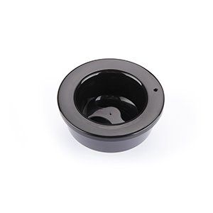 Un recipiente negro con un agujero en el medio sobre un fondo blanco.