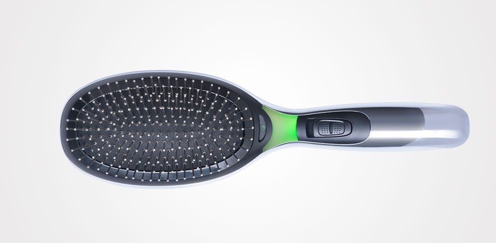 Un cepillo de pelo negro y verde con un mango verde sobre un fondo blanco.