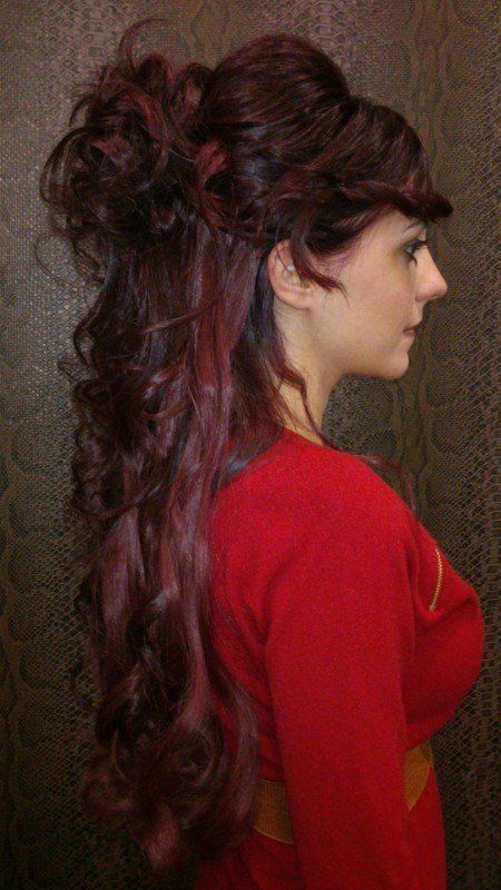 Una mujer con cabello largo y rojo lleva una camisa roja.