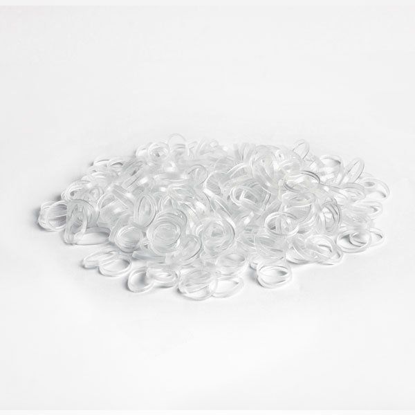 Una pila de bandas elásticas transparentes sobre una superficie blanca.