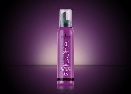 Una botella morada de mousse de igora sobre un fondo morado.