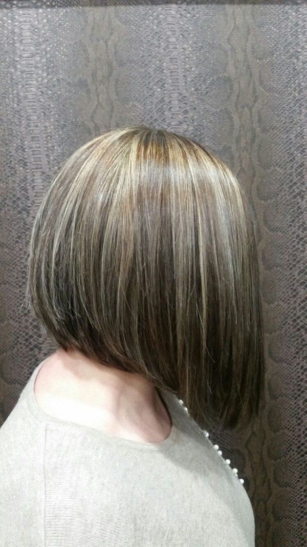 Una mujer con pelo corto lleva un suéter blanco.