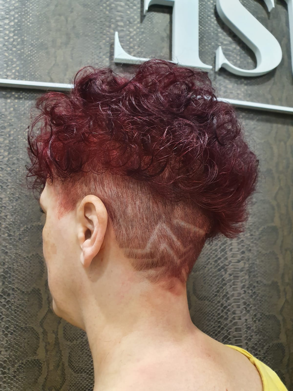 Una mujer con cabello rojo tiene un diseño rapado en la parte posterior de su cabeza.