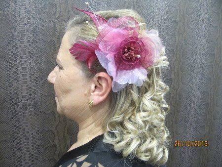 Una mujer lleva una flor rosa en el pelo.