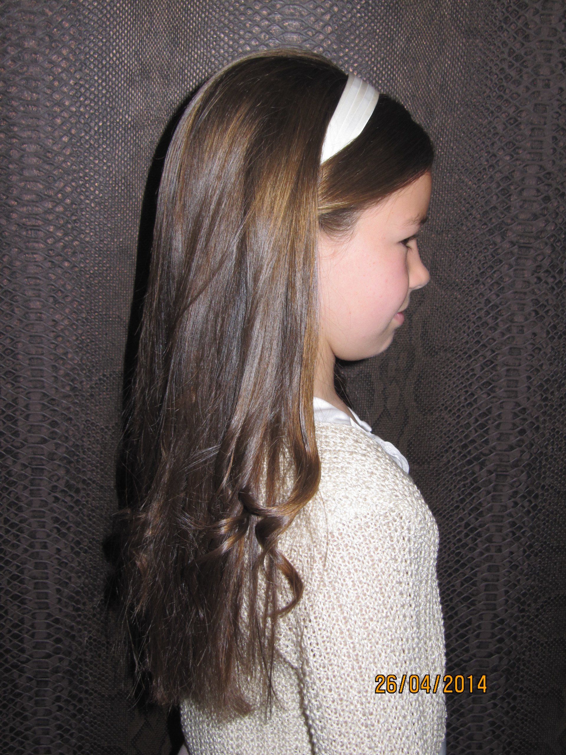 Una niña con cabello largo que lleva una diadema blanca