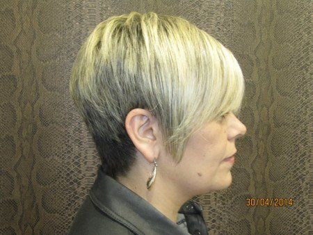 Una mujer con cabello rubio corto lleva aretes