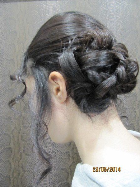 Una mujer lleva el pelo recogido en un moño trenzado.