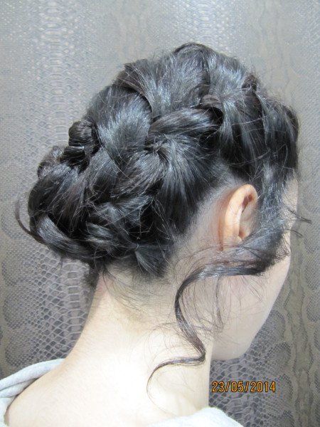 Una mujer lleva el pelo recogido en un moño trenzado.