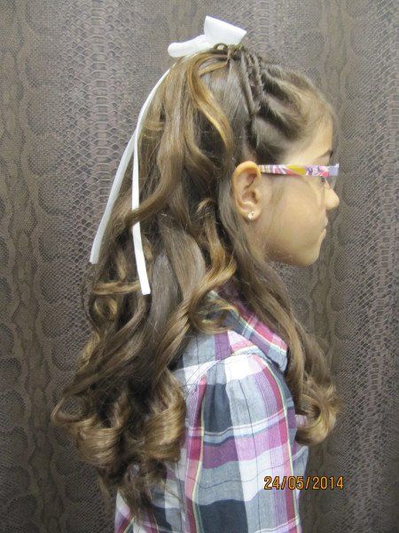 Una niña con pelo largo y gafas lleva una camisa a cuadros.