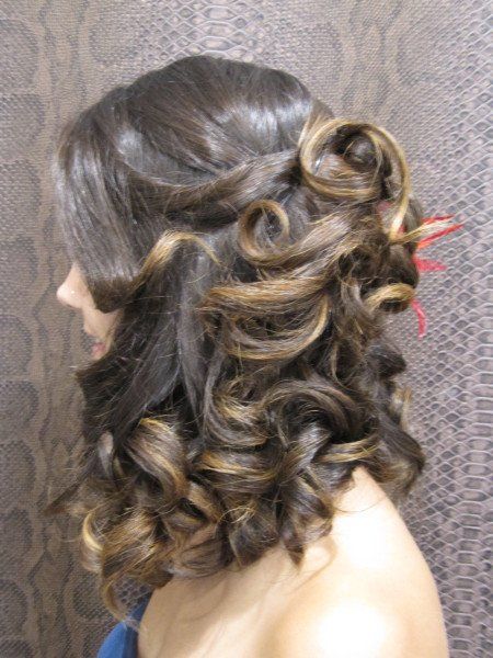 Una mujer con cabello largo y rizado lleva un vestido azul.