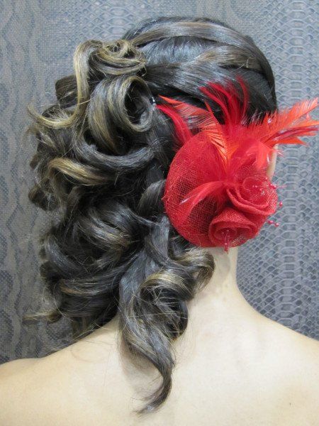 Una mujer lleva una flor roja en el pelo.