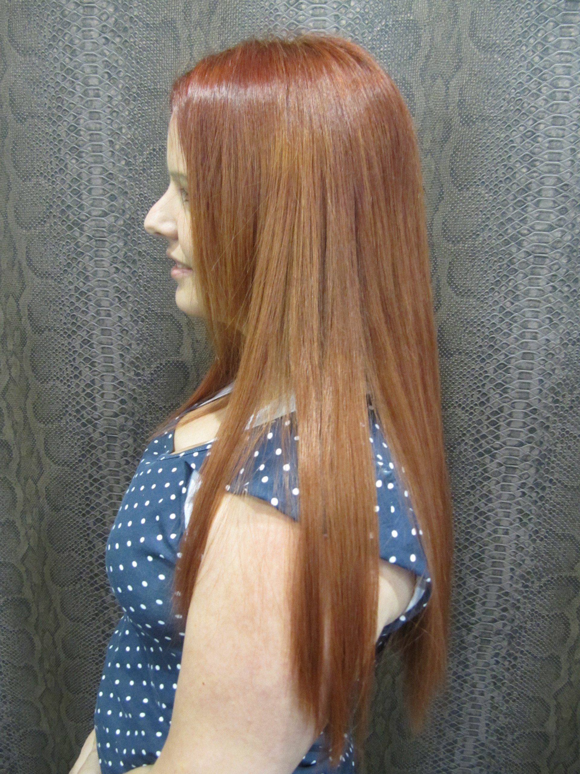 Una mujer con cabello largo y rojo lleva un vestido de lunares azules.