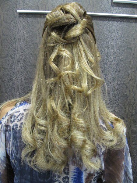 Una mujer con cabello largo y rubio lleva un peinado mitad recogido y mitad suelto.