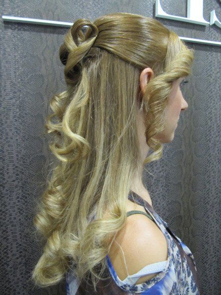 Una mujer con cabello largo y rubio tiene el cabello recogido mitad arriba y mitad abajo.