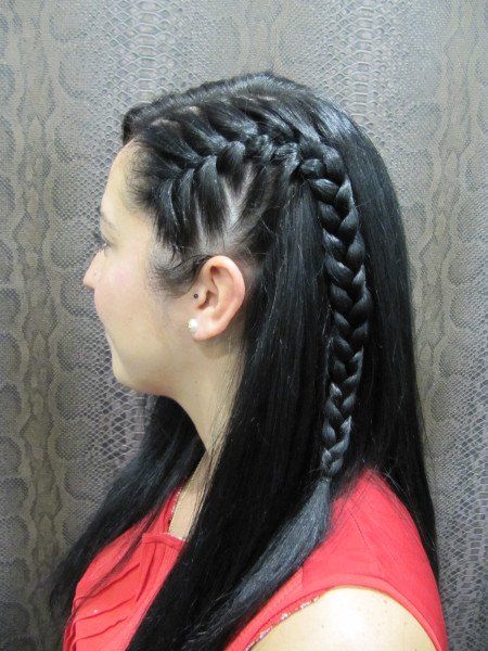 Una mujer con una camisa roja tiene una trenza en el pelo.