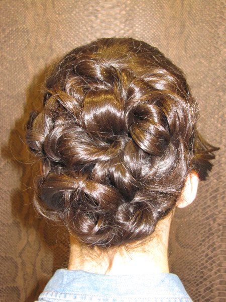 La parte posterior de la cabeza de una mujer con el cabello recogido en un moño desordenado.