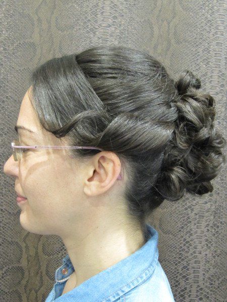 La mujer lleva gafas y tiene el pelo recogido en un moño.