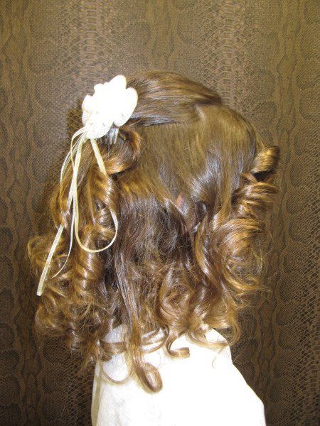 Una niña con cabello rizado y una flor en el pelo.