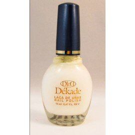 Una botella de esmalte de uñas Dekade reposa sobre una superficie blanca.