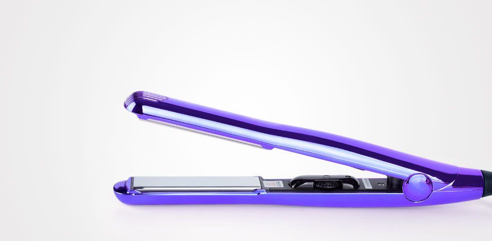 Una plancha de pelo morada reposa sobre una superficie blanca.