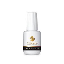 Una botella de pegamento para puntas de uñas Silcare sobre un fondo blanco.