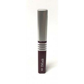 Una botella de rímel reposa sobre una superficie blanca.