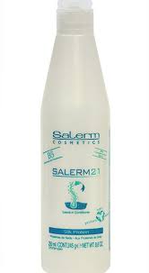 Una botella blanca de champú Salerm 21 sobre un fondo blanco.