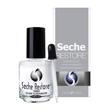 Una botella de esmalte de uñas seche restore al lado de una caja.