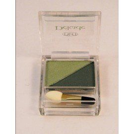 Una sombra de ojos verde en una caja transparente con un pincel.