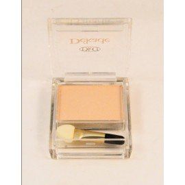 Un recipiente cuadrado de sombra de ojos con un pincel dentro.