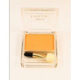 Una sombra de ojos amarilla en una caja transparente con un pincel.