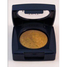 Una sombra de ojos dorada en una caja negra con la tapa abierta