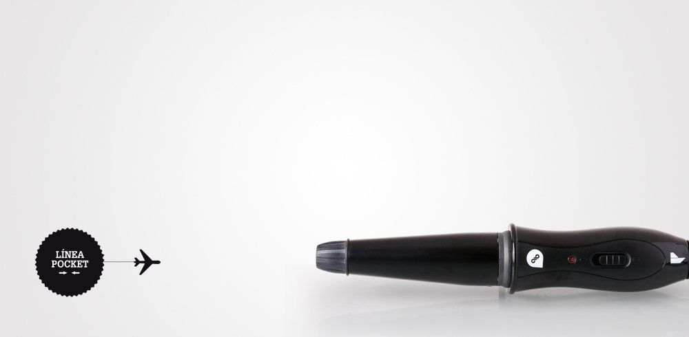 Un rizador de pelo negro está sobre una superficie blanca.