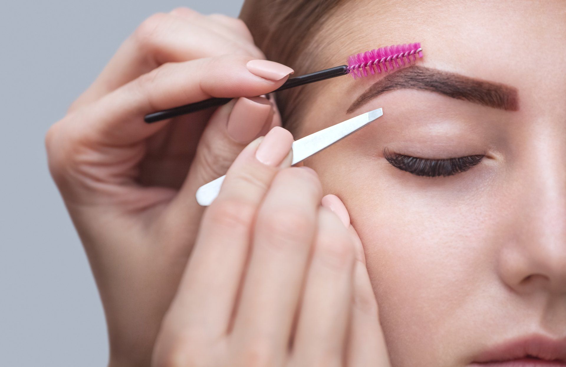 Una mujer se está pintando las cejas con un pincel.