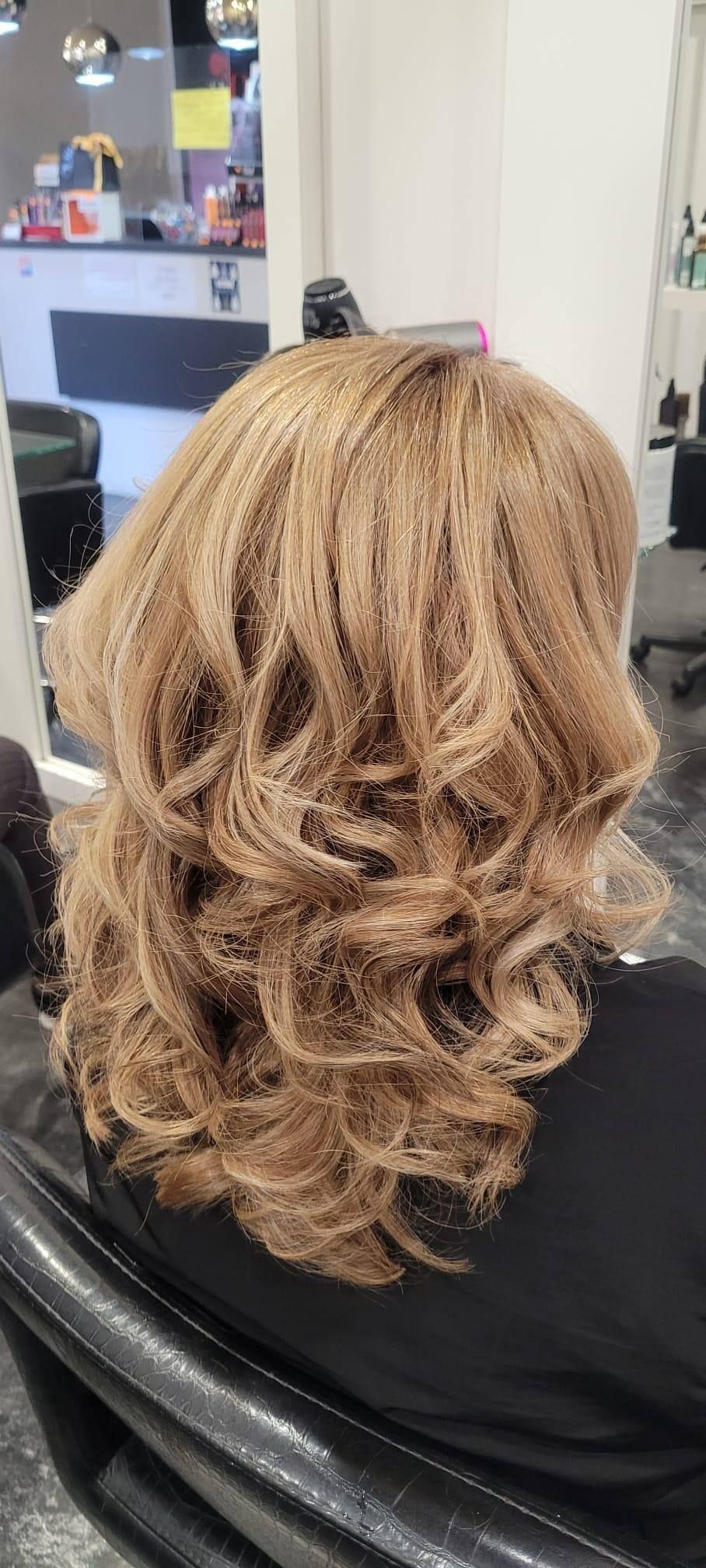 Una mujer está sentada en una silla con su cabello en un salón.