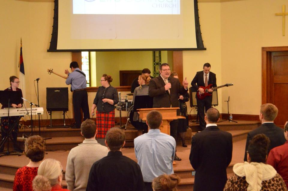 A group of people standing in front of a projector screen