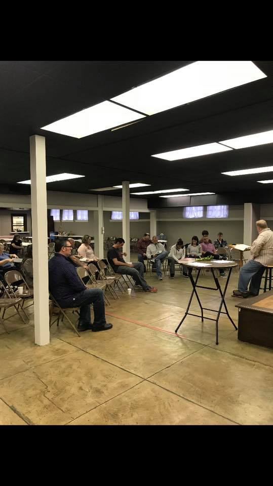 A group of people are sitting at tables in a large room.