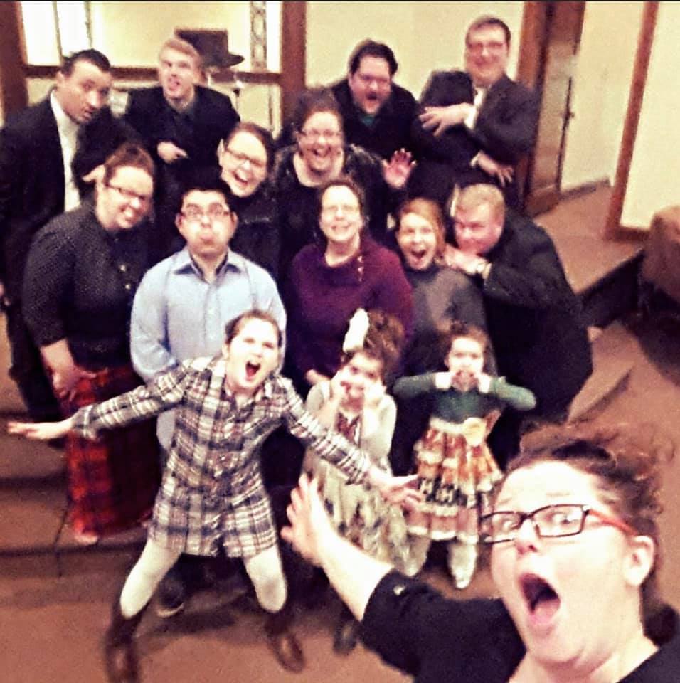 A group of people posing for a picture with one woman wearing glasses