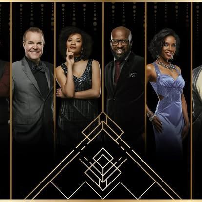 Group of six people, dressed in formal attire, posing for a photo in front of a black and gold art deco background.