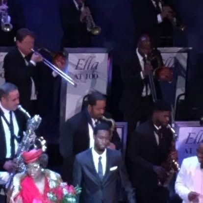 Jazz band onstage; men in suits play instruments; 