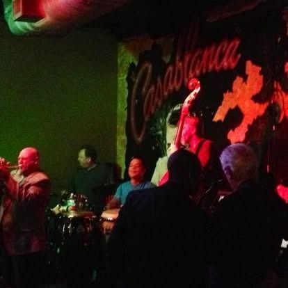 Band performing at Casablanca club, lights, people in shadows.