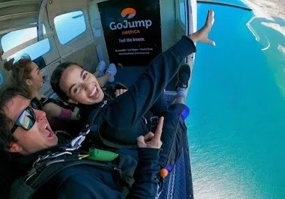 HWH San Diego Hard Money Lender - Real Estate highlights adventure and lifestyle opportunities near GoJump Oceanside. The image captures skydivers soaring above the Pacific coastline, with breathtaking ocean and city views below.