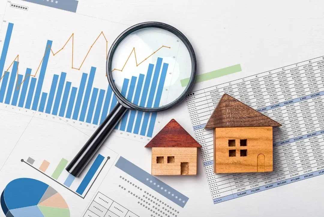 HWH San Diego Hard Money Lender - Real Estate displays a magnifying glass placed on a worksheet with a small wooden house beside it, symbolizing detailed property analysis. The setup reflects the importance of careful evaluation in real estate investments and lending decisions.
