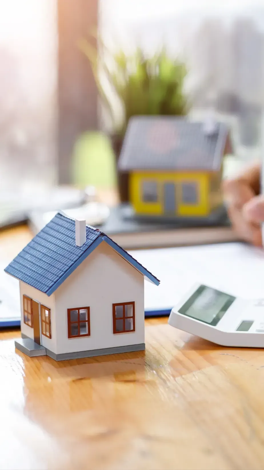 San Diego Hard Money Lender - The image shows a wooden house on stacked coins, symbolizing property investment, with 