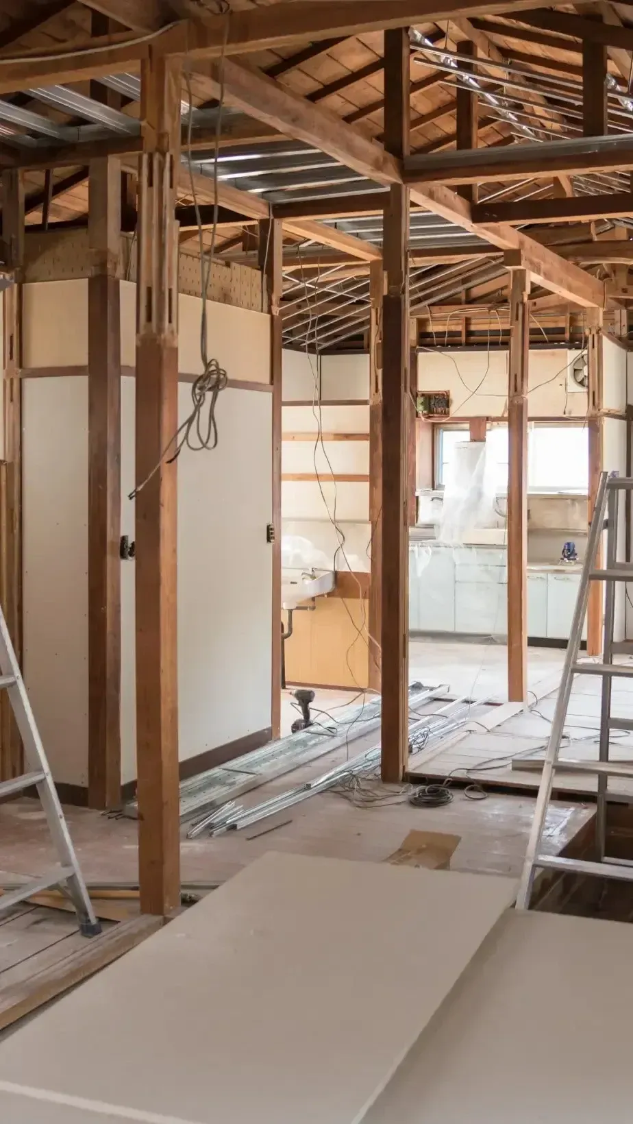 San Diego Hard Money Lender - The photo showcases an unfinished interior with exposed wooden ceiling beams, electrical wiring, and partially removed walls, indicating an active remodeling project.