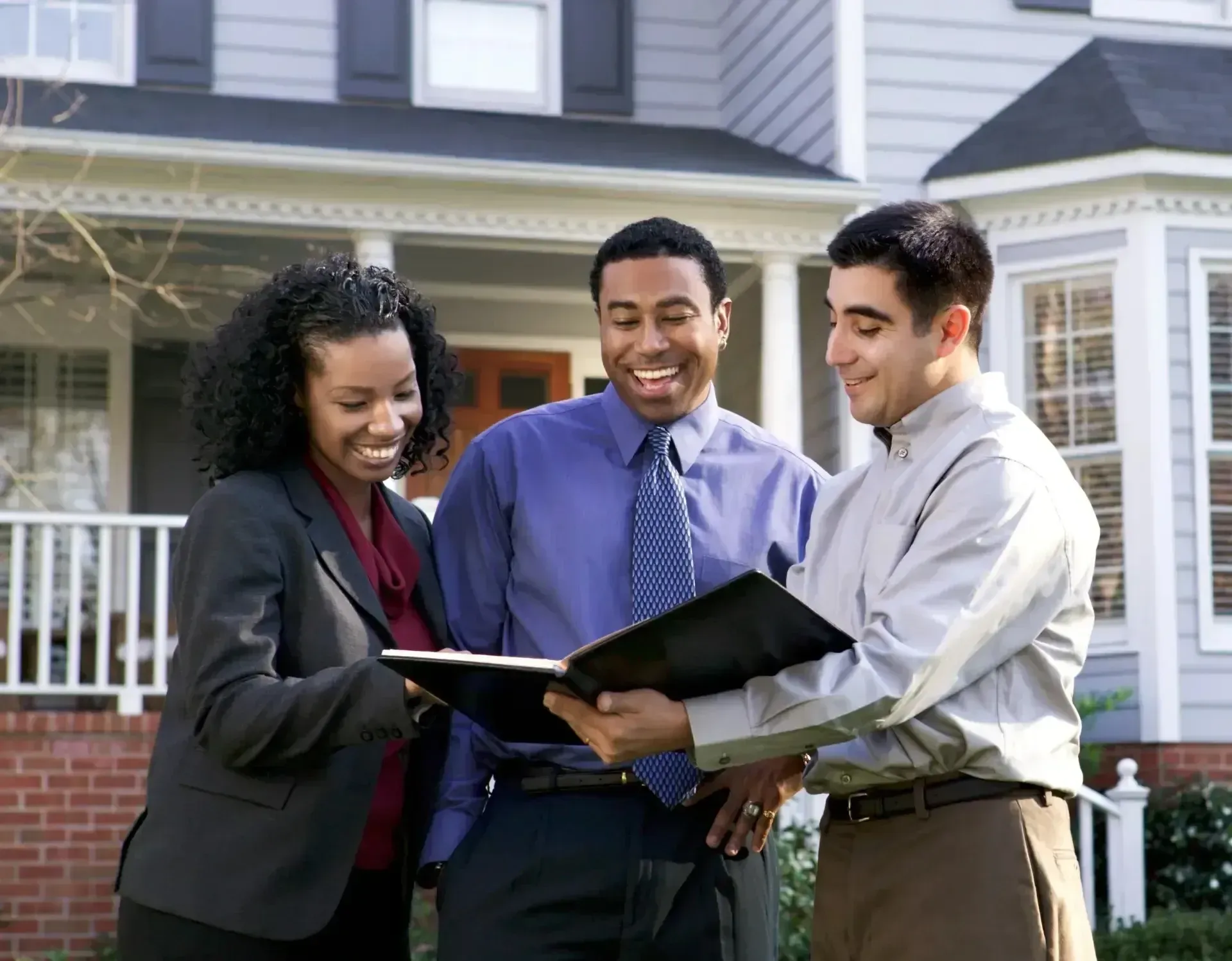 San Diego Hard Money Lender - The image features three professionals reviewing documents in front of a house, highlighting seamless financing solutions.