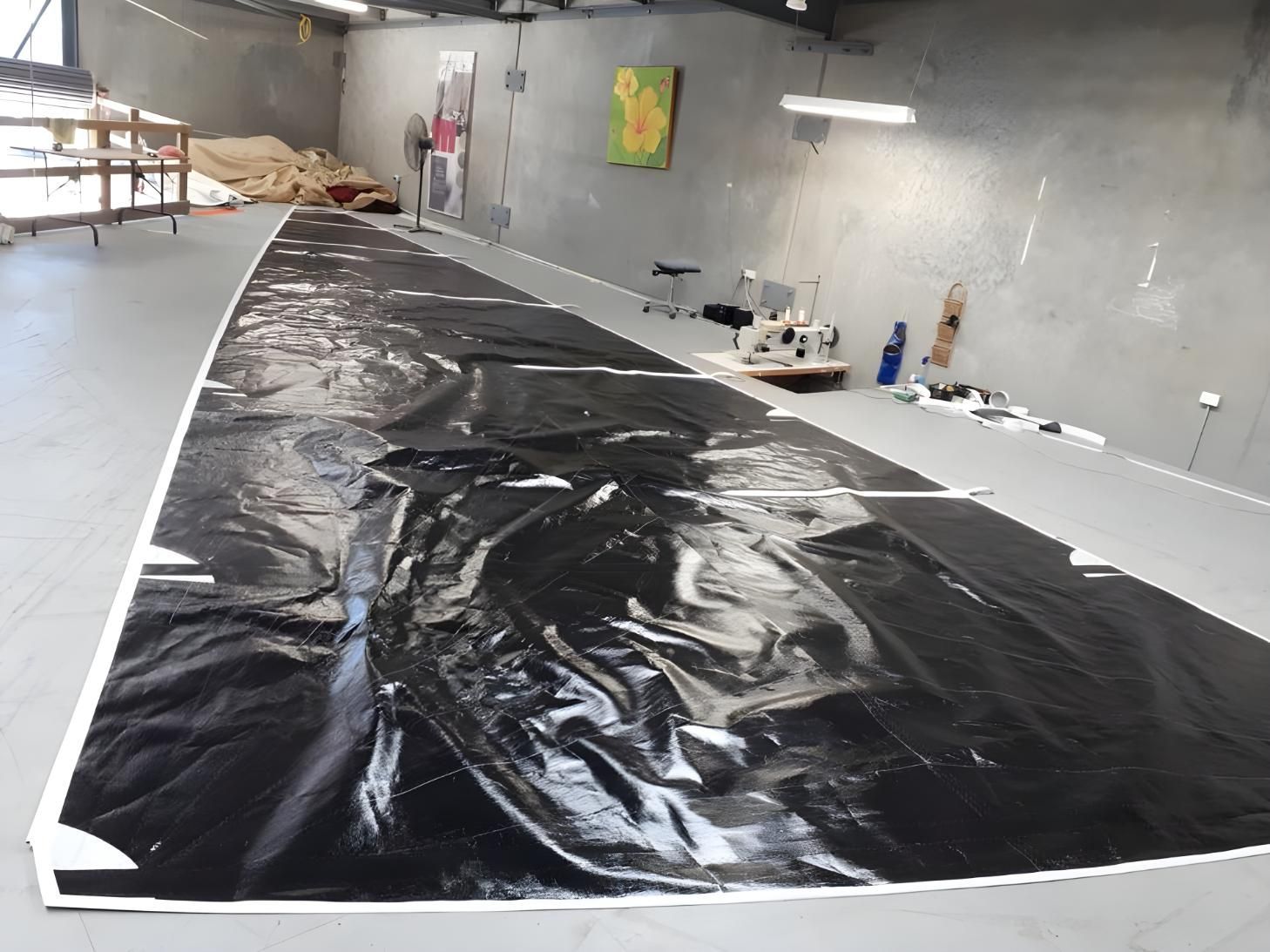 A Large Piece of Black Plastic is Laying on the Floor in a Room — Off Shore Sails & Rigging In North Boambee Valley, NSW