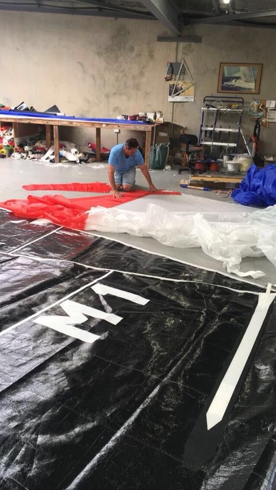A Boat is Being Lifted Into the Water by a Crane — Off Shore Sails & Rigging In North Boambee Valley, NSW