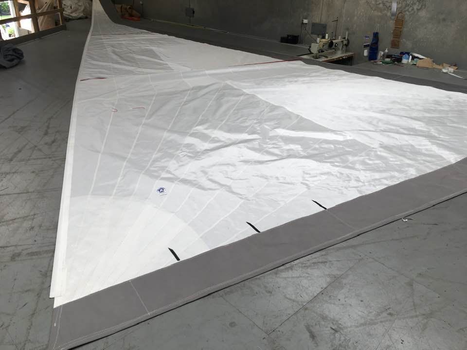 A Large White Sail is Sitting on a Concrete Floor — Off Shore Sails & Rigging In North Boambee Valley, NSW
